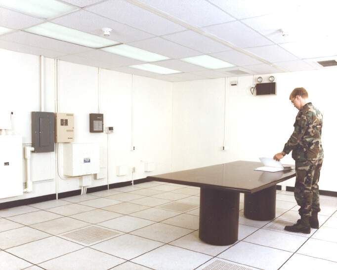 man in uniform standing at the table in a SCIF room